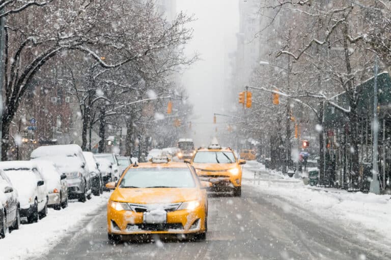 Taxis,Drive,Down,A,Snow,Covered,5th,Avenue,During,A