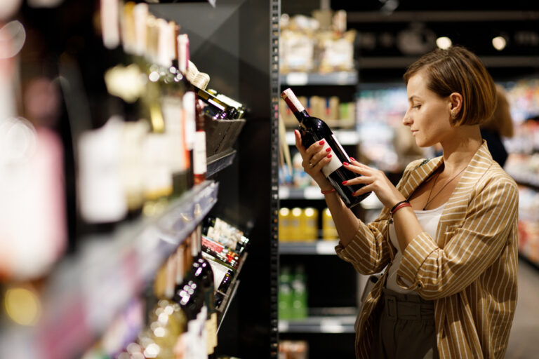 Girl,In,White,Jersey,And,Jacket,Chooses,Wine,In,Supermarket