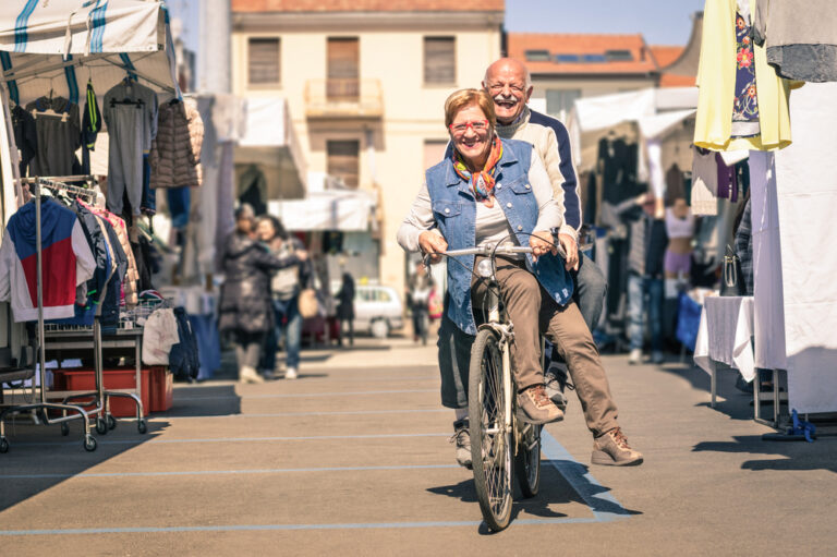 Happy,Senior,Couple,Having,Fun,With,Bicycle,At,Flea,Market