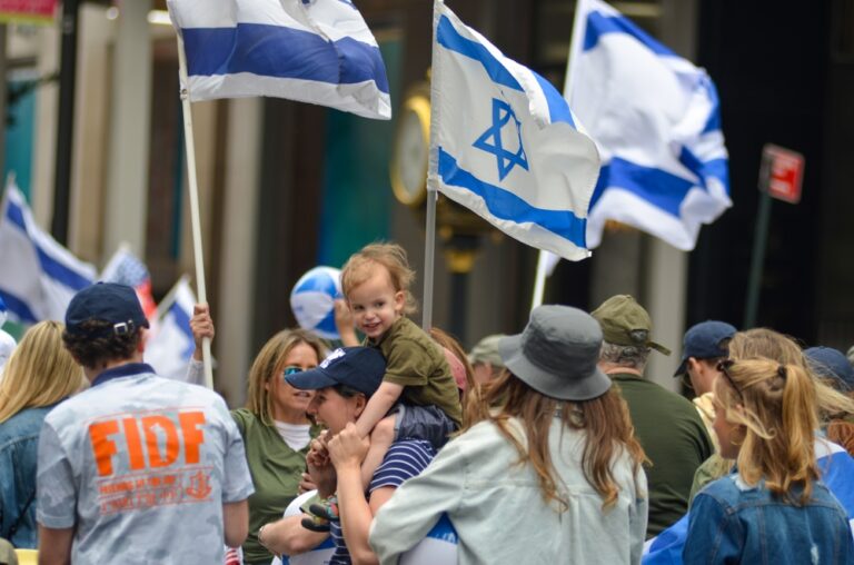 A,Young,Parade,Participant,Is,Seen,Holding,Israeli,Flags,As