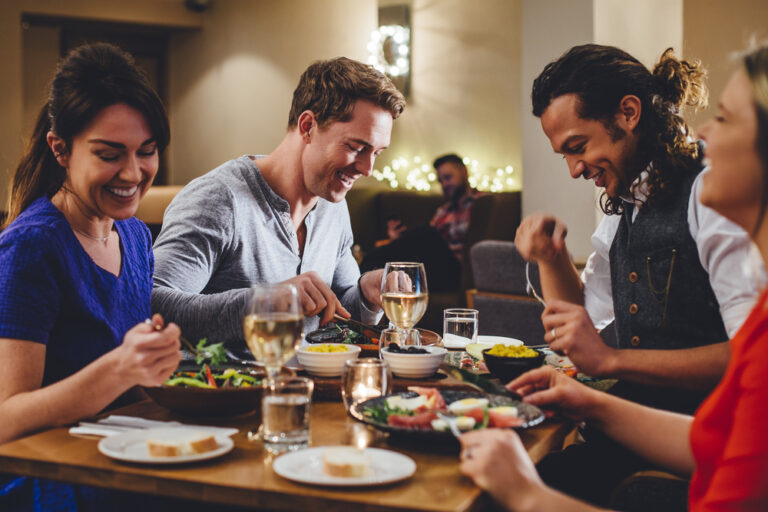 Group,Of,Friends,Enjoying,An,Evening,Meal,With,Wine,At