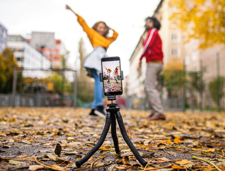 Young,Couple,With,Smartphone,Making,Video,For,Social,Media,Outdoors