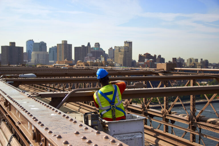 Construction,Worker,On,Brooklyn,Bridge,At,Sunny,Day