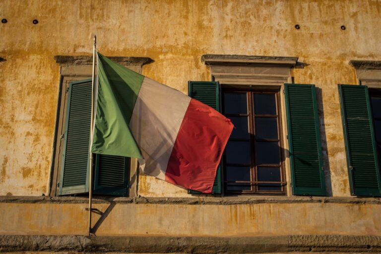Italian,Flag,Over,Window's,Yellow,House,-,Italy