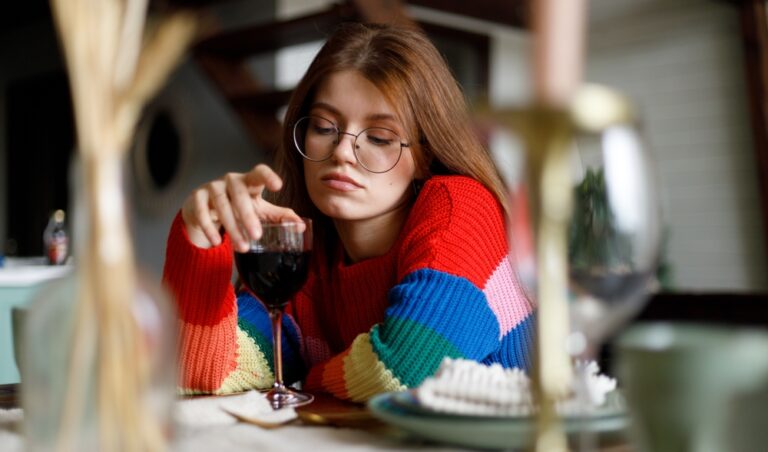 Sad,Young,Woman,With,A,Glass,Of,Wine,Sits,At