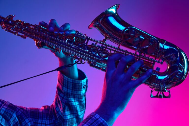 Cropped,Portrait,Of,Jazzman,Playing,Saxophone,Against,Gradient,Blue-pink,Background