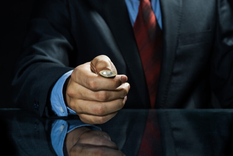Close,Up,Of,Businessman,Holding,Coin,In,Hand