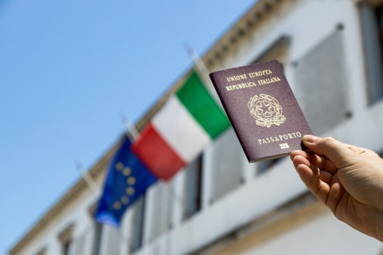 Hand,Holding,Italian,Passport,With,Italy,And,European,Union,Flags