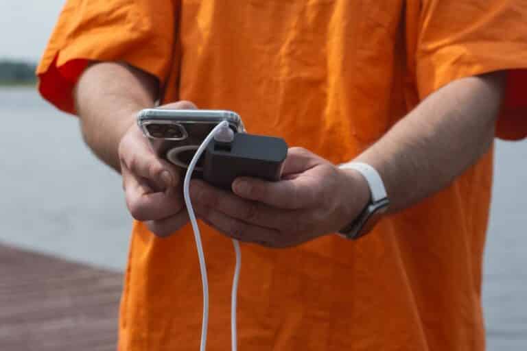 Man,Charging,Smartphone,With,Power,Bank,By,Lake,Using,Usb