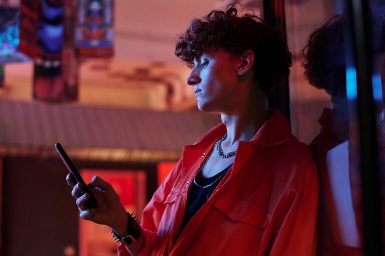 Guy,With,Curly,Hair,In,Stylish,Attire,Looking,At,Smartphone